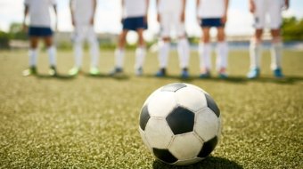 Ball on Grass in Junior Football Match