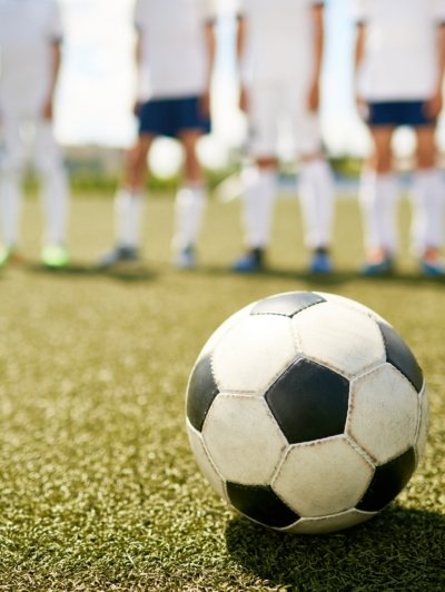 Ball on Grass in Junior Football Match